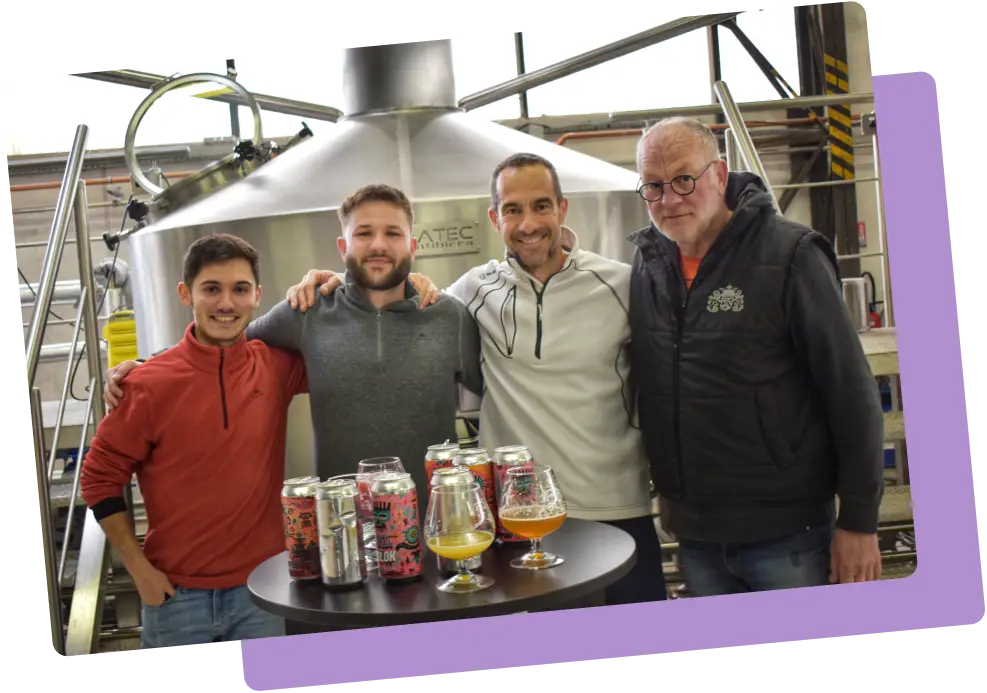 Équipe de la Brasserie La Tuilerie posant devant les cuves avec des bières artisanales