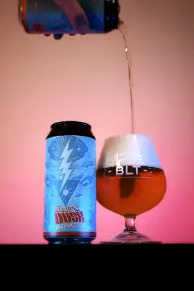 Bière artisanale BLT servie dans un verre avec une canette White Mist en arrière-plan